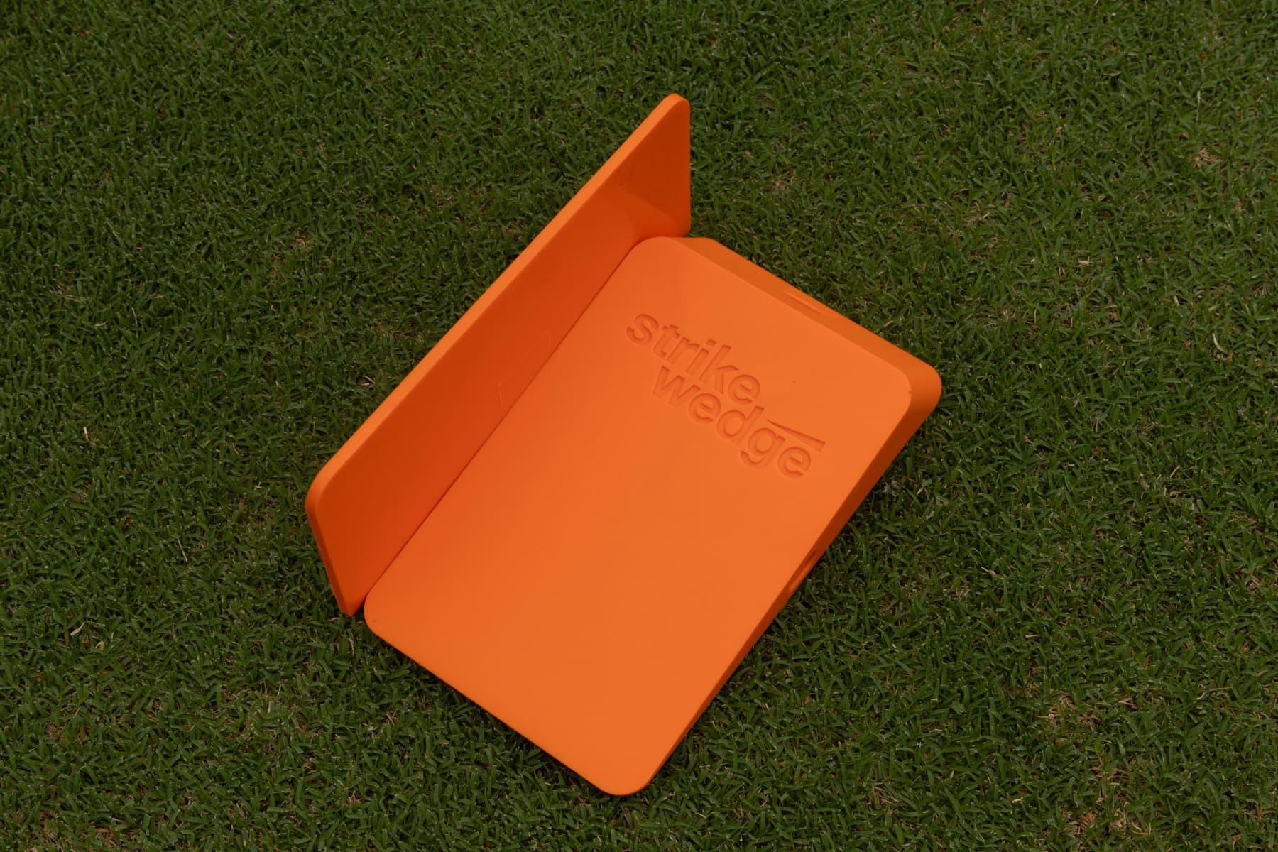 Strike Wedge open flat on the green, showing the embossed wordmark